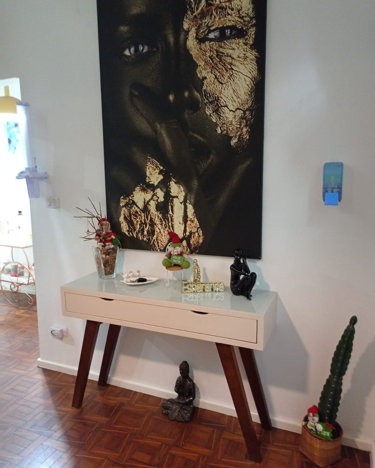 Hall do Second Home com aparador branco, quadro artístico de grande formato e objetos de decoração