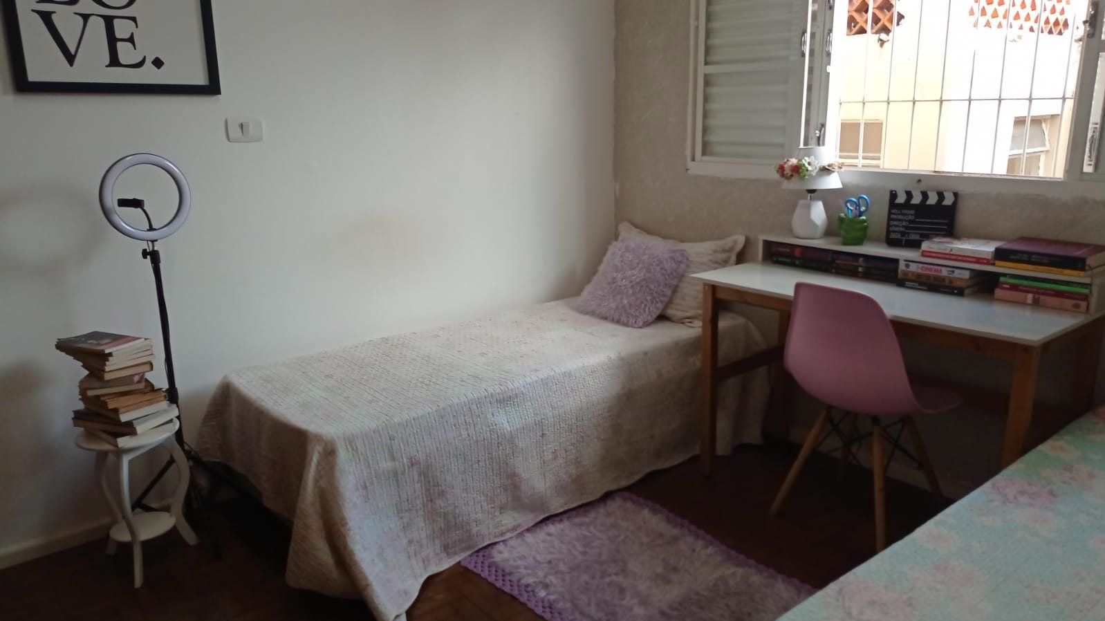 Quarto individual branco do Second Home com cama, mesa de trabalho e boa iluminação natural