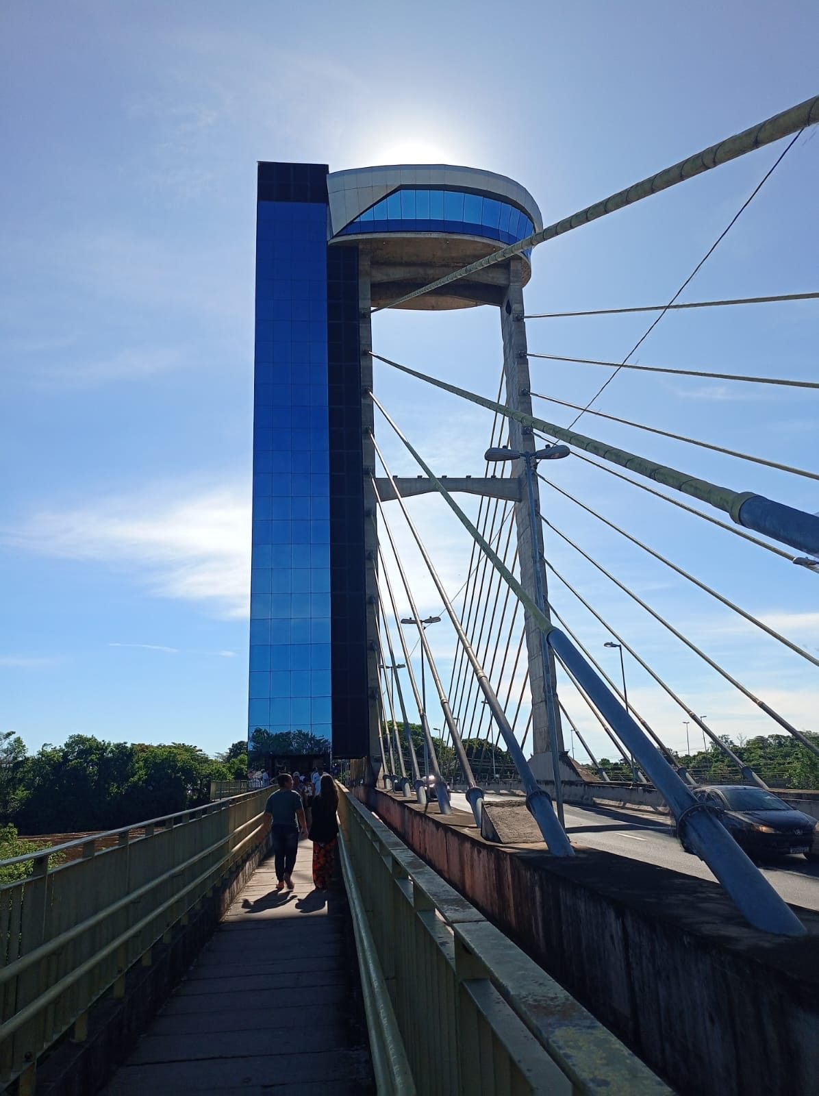 Passarela de ponte em Salto, com torre de vidro azul e céu limpo
