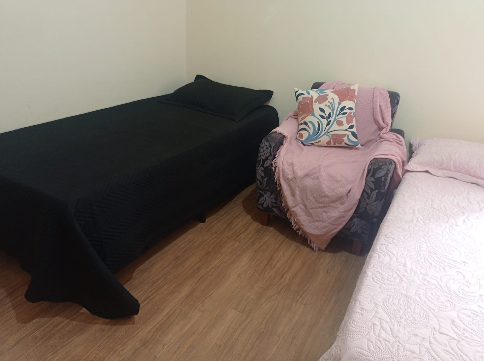 Quarto compartilhado do Second Home com duas camas e piso laminado