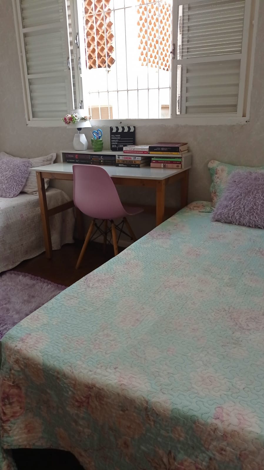 Quarto mobiliado do Second Home Coliving, com cama, escrivaninha, cadeira e janela iluminada