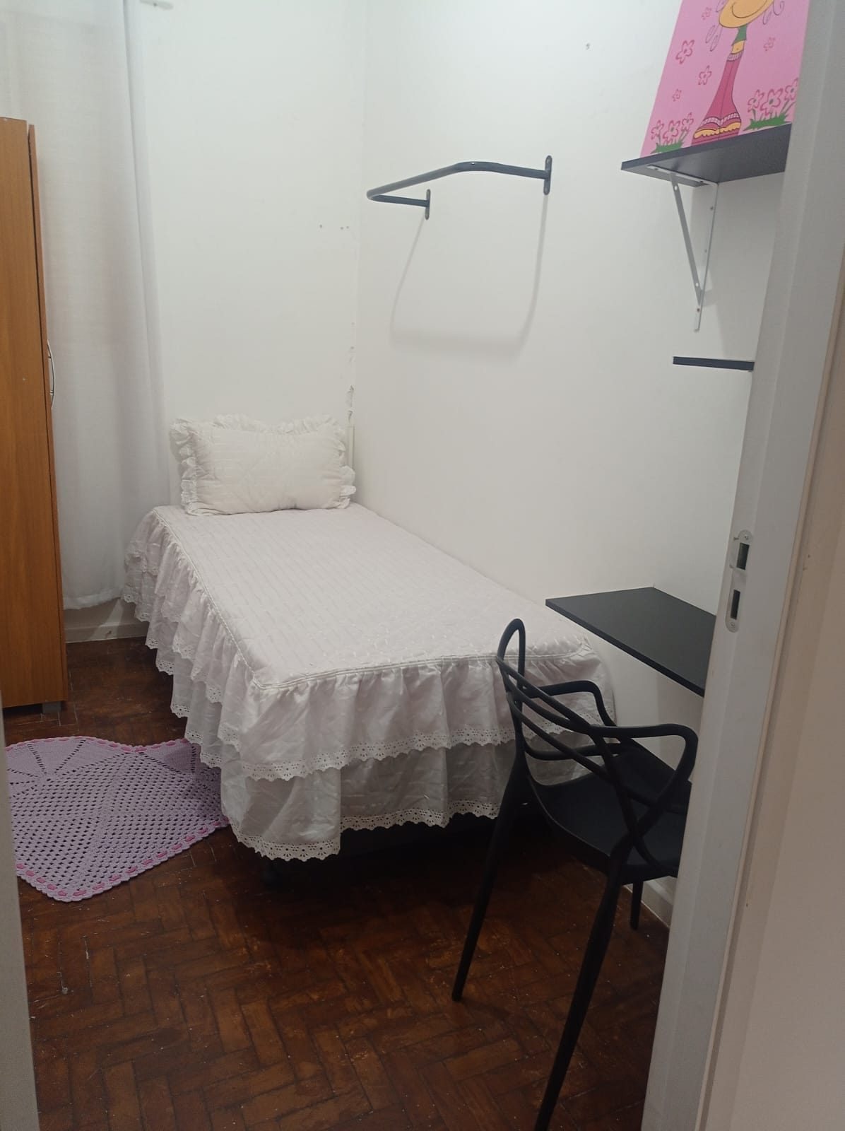 Quarto individual do Second Home com cama, mesa suspensa e guarda-roupa